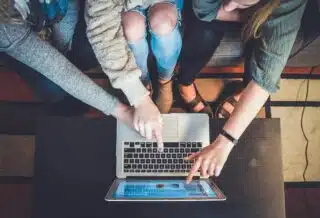 un groupe de collègues regardant l'écran d'un ordinateur